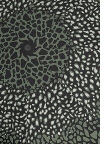 Ombrello pieghevole con base in tessuto nero e un motivo astratto verde e bianco che imita forme e texture organiche.