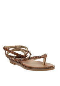 Sandalias de cuero marrón con un diseño de tiras intrincado, que presenta tachuelas de metal y acentos en forma de sol, suela plana y separación para los dedos.