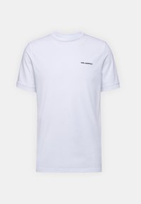 Vit bomulls-t-shirt med korta ärmar och rundad halsringning. Har en liten svart "KARL LAGERFELD"-logotyp på övre vänstra sidan.