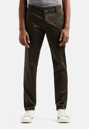 Chinos verde oliva realizzati in tessuto misto cotone, caratterizzati da una vestibilità slim, chiusura con bottone e tasche frontali, abbinati a sneaker bianche.