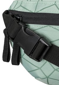 Marsupio verde chiaro con un motivo geometrico, dotato di una cerniera nera e chiusura a fibbia, tessuto testurizzato e spallacci neri regolabili.