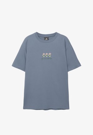 T-shirt in cotone azzurro chiaro con maniche corte, caratterizzato da un design floreale ricamato con fiori rosa e steli verdi sul petto.