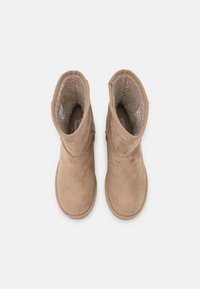 Paire de bottes d'hiver en daim beige avec doublure en polaire, vue de dessus sur un fond blanc.