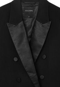 Schwarzer sacko mit Doppelreiher, satinierte Revers und passende Stoffknöpfe, mit einem Calliope-Label im Kragen.