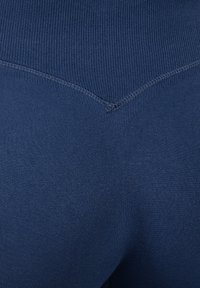 Donkerblauwe leggings van rekbaar materiaal met een geribde tailleband en platte naden, met een licht gestructureerd oppervlak en een nauwsluitend ontwerp.