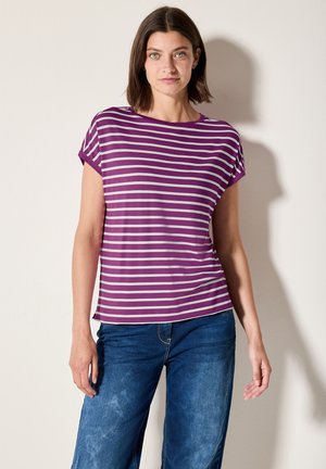 Top a maniche corte a righe viola e bianche, vestibilità rilassata, collo rotondo, tessuto morbido, abbinato a jeans in denim blu, superficie texture.
