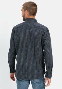 Heren overhemd met lange mouwen in marineblauw met een geometrisch patroon. Voorzien van een kraag, knoopmanchetten en een relaxte pasvorm, gemaakt van lichtgewicht stof.