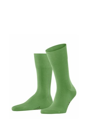 Grüne knielange Socken aus glattem, dehnbarem Material. Sie verfügen über einen gerippten Bund und ein dezentes Logo-Detail an der Spitze.