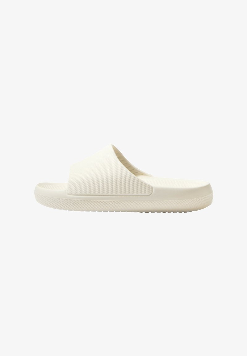 White rubber slide sandal with a textured surface, open toe design, and flat sole featuring a grip pattern for traction.