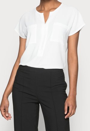 Witte blouse met korte mouwen en een V-hals, twee borstzakken en een zachte, gladde textuur; gecombineerd met zwart, hooggetailleerd broek.