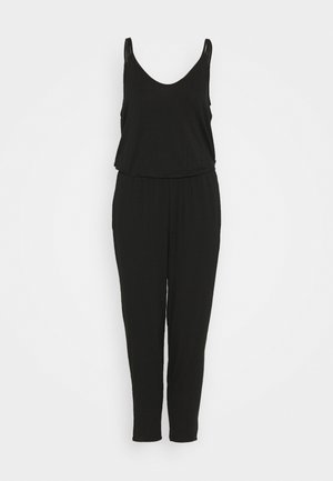 Černý overal bez rukávů s výstřihem do V, elastickým pasem a zúženými nohavicemi na jednobarevném bílém pozadí.
