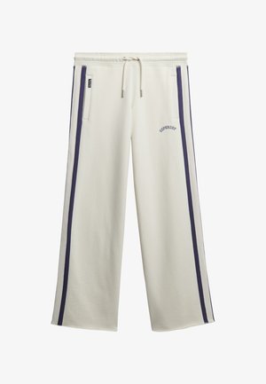 Pantaloni da jogging larghi color crema con strisce laterali blu, cintura con cordino, tasche frontali e logo "Superdry" sulla coscia sinistra.