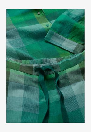 Roheline ruuduline särk ja vastavad püksid, millel on erinevad roheline tooni ja kontrollmustreid, nööpidega esiosa ning elastne vöökoht.