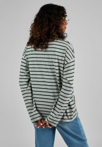 Gestreiftes Langarmshirt in Grau und Dunkelgrün, mit lockerer Passform und weiten Ärmeln, kombiniert mit hellblauen Jeans.