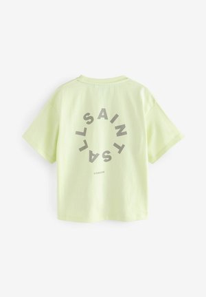 T-shirt verde chiaro a maniche corte con una grafica circolare e il testo "SAINT LONDON" in lettere grigie in grassetto sul retro.
