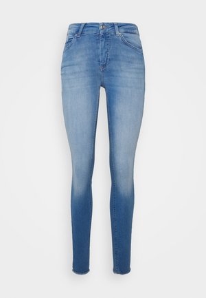 Jeans ajustados em denim azul claro com um design desbotado. Apresentam uma cintura média, estilo de cinco bolsos e acabamentos desfiados na barra.