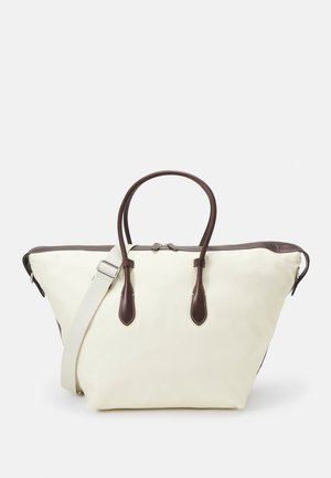 Borsa tote in canvas color crema con accenti in pelle marrone scuro, forma strutturata, doppi manici superiori e tracolla staccabile.