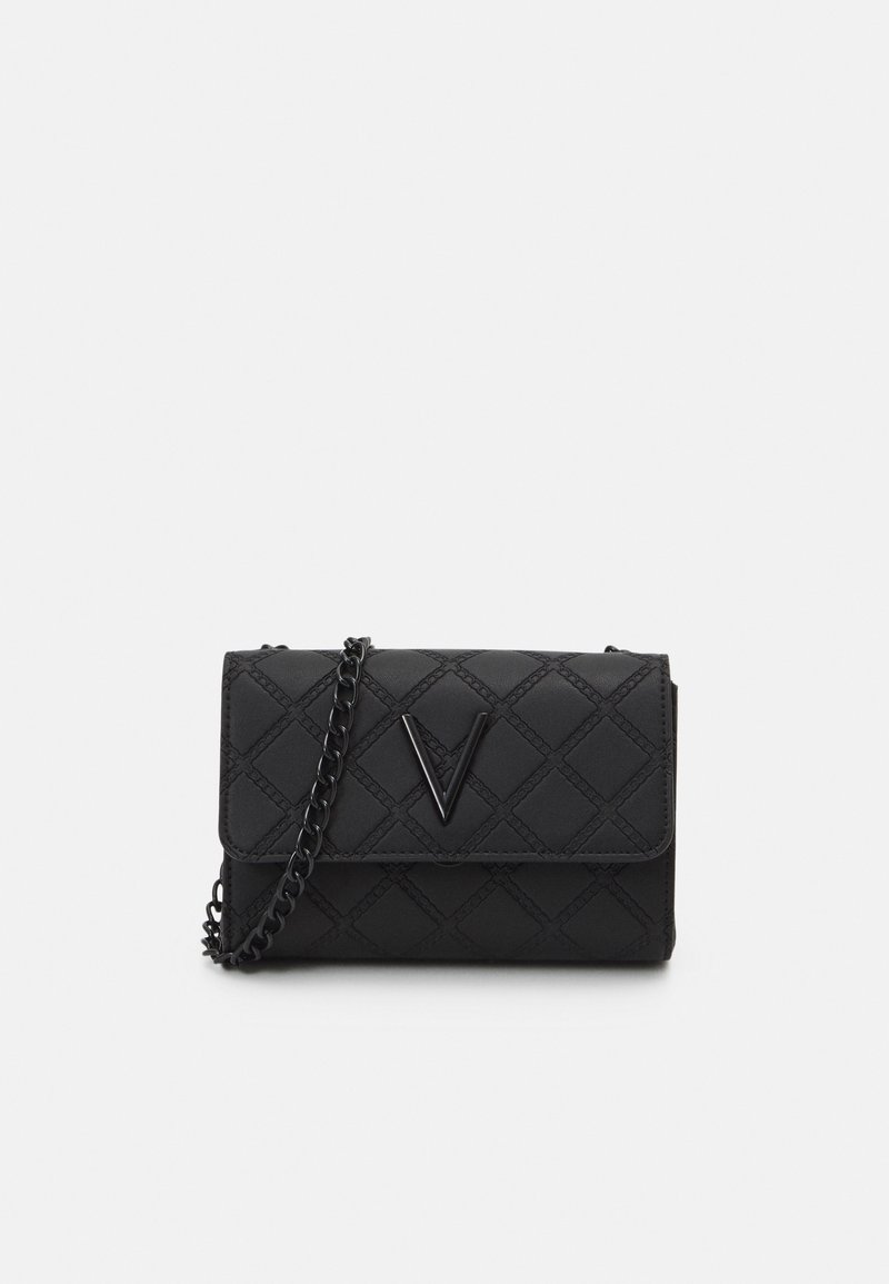 Musta tikattu olkalaukku, jossa ketjuhihna, kiiltävä etulogo ja jämäkkä suorakulmainen muoto. Sileä pinta.