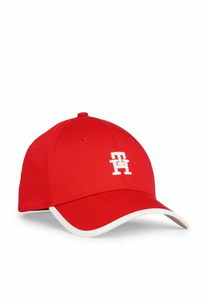 Rød baseballkasket med hvidt broderet "TH" logo på forsiden og hvid kant langs den buede skygge, vist mod en hvid baggrund.