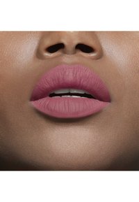 Rouge à lèvres mat dans une teinte rose doux sur des lèvres lisses et pleines. La peau a un sous-ton chaud avec une finition naturelle, mettant en valeur la couleur des lèvres.