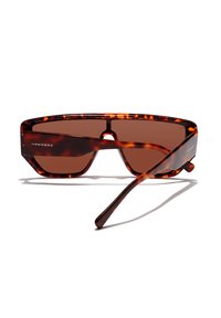 Ochelari de soare cu model țestoasă, design unghiular, lentile maro și finisaj lucios; prezintă logo-ul "HAWKERS" pe templu.