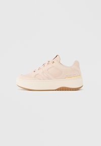 Zapatilla deportiva de plataforma en rosa rubor con cordones delanteros, detalles de paneles cosidos y una suela gruesa beige con dibujo marrón.