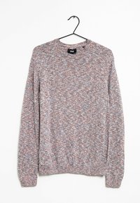 Stickad tröja med långa ärmar i blandade grå, vita och bruna garn som hänger på en svart metallgalge mot en vit bakgrund.