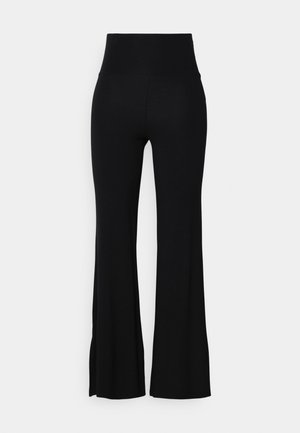 Pantaloni negri evazați dintr-un material elastic, cu talie înaltă și o textură netedă. Aventajul se lărgește ușor de la genunchi.
