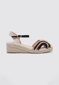 Sandalia de cuña con suela de yute trenzado, que presenta un upper textil a rayas en beige y negro y una correa ajustable en el tobillo.