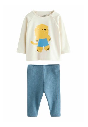 Tvådelad barnoutfit som består av en gräddfärgad långärmad topp med en gul lejongrafik och blå ribbade leggings.