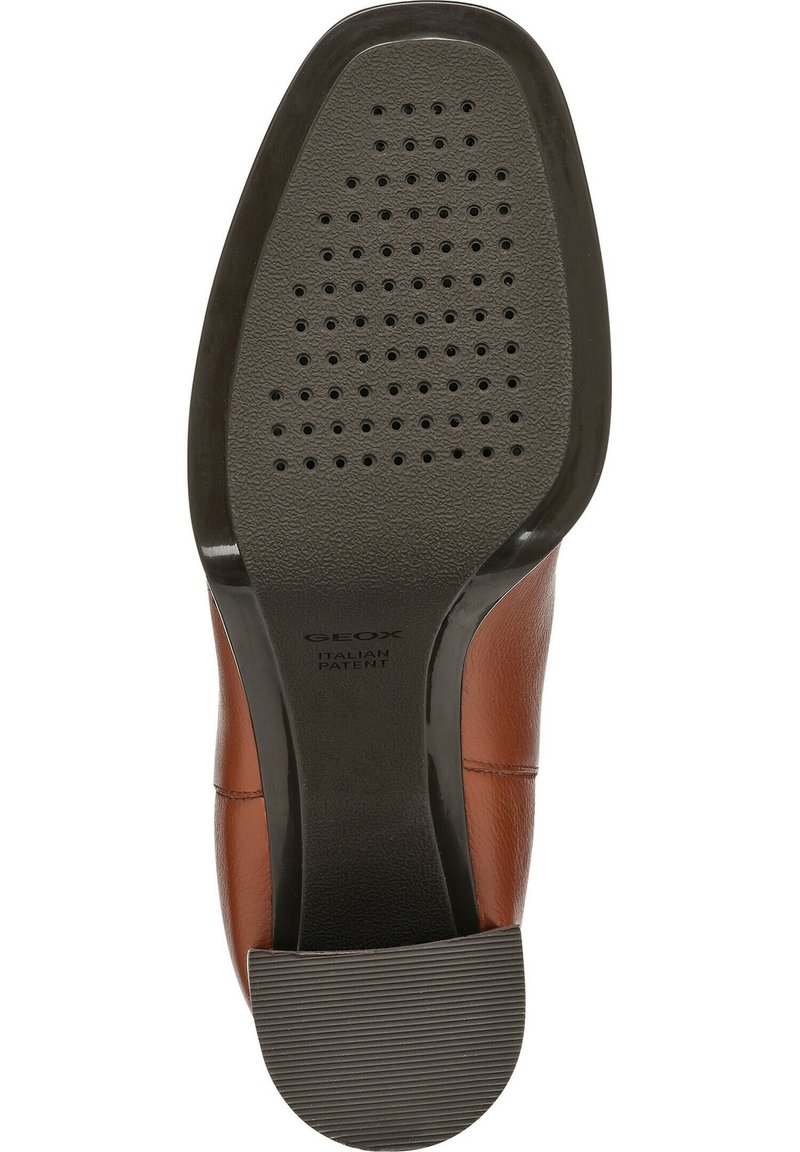 Semelle en cuir marron avec un talon en caoutchouc noir texturé. Présente de petits trous de drainage et une marque embossée à l'arrière.