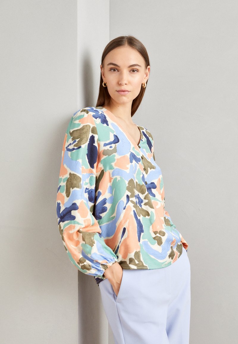 Blusa multicolore in tessuto leggero, con scollatura a V, maniche a palloncino e un motivo floreale astratto nei toni pastello.