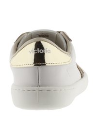 Sneaker in pelle bianca con una finitura liscia, dotata di una cappetta a righe dorate sul tallone e di un accento in suede marrone chiaro, con il marchio "victoria" sul retro.
