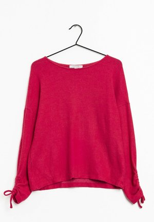 Roter Pullover mit langen Ärmeln, Boot-Ausschnitt und gebundenen Bündchen, hängend an einem schwarzen Metallbügel vor weißem Hintergrund.