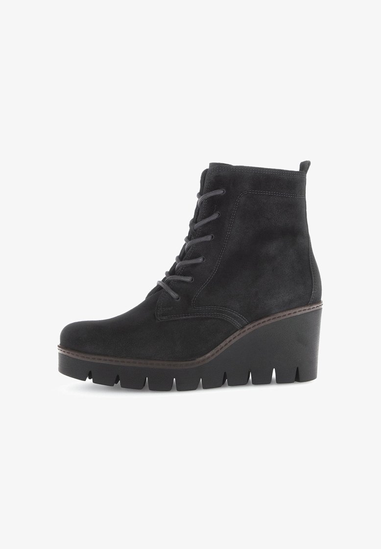 Bottine en suède noir avec un talon compensé haut, fermeture à lacets sur le devant, surface texturée et détail de couture contrastante le long de la semelle.