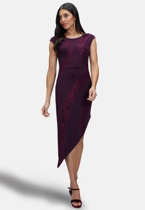 Asymmetrical burgundy dress with cap sleeves, featuring lace insets and a fitted bodice, creating a sleek silhouette. Textured fabric detail.