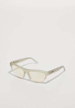 Occhiali da sole con una montatura traslucida e chiara e lenti giallo chiaro, caratterizzati da bordi curvi e un marchio discreto sulle stanghette.