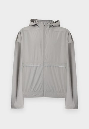 Veste coupe-vent à capuche gris clair avec fermeture éclair frontale et taille élastique, conçue pour une utilisation légère en extérieur.