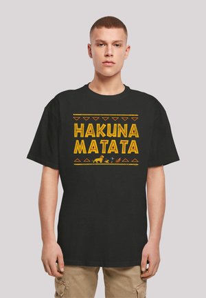 Black cotton t-shirt featuring the phrase "HAKUNA MATATA" in large yellow letters, accented by a colorful tribal pattern and animal silhouettes.
