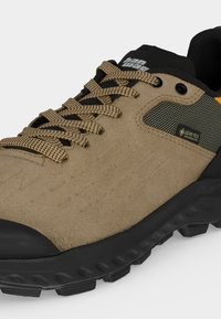 Μπεζ πεζοπορικό παπούτσι με μαύρη σόλα, μπεζ κορδόνια με σχέδια, ετικέτα Gore-Tex και μαύρο επενδεδυμένο κολάρο. Ανθεκτική εξωτερική σόλα για πρόσφυση.
