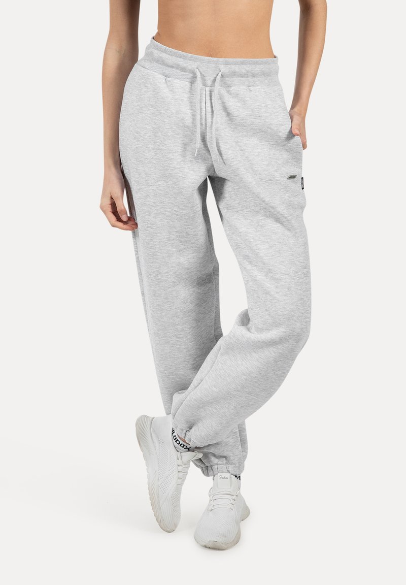Grijze katoenen sweatpants met een elastische tailleband, verstelbaar trekkoord en zijzakken, die naar de enkel toe taps toelopen.
