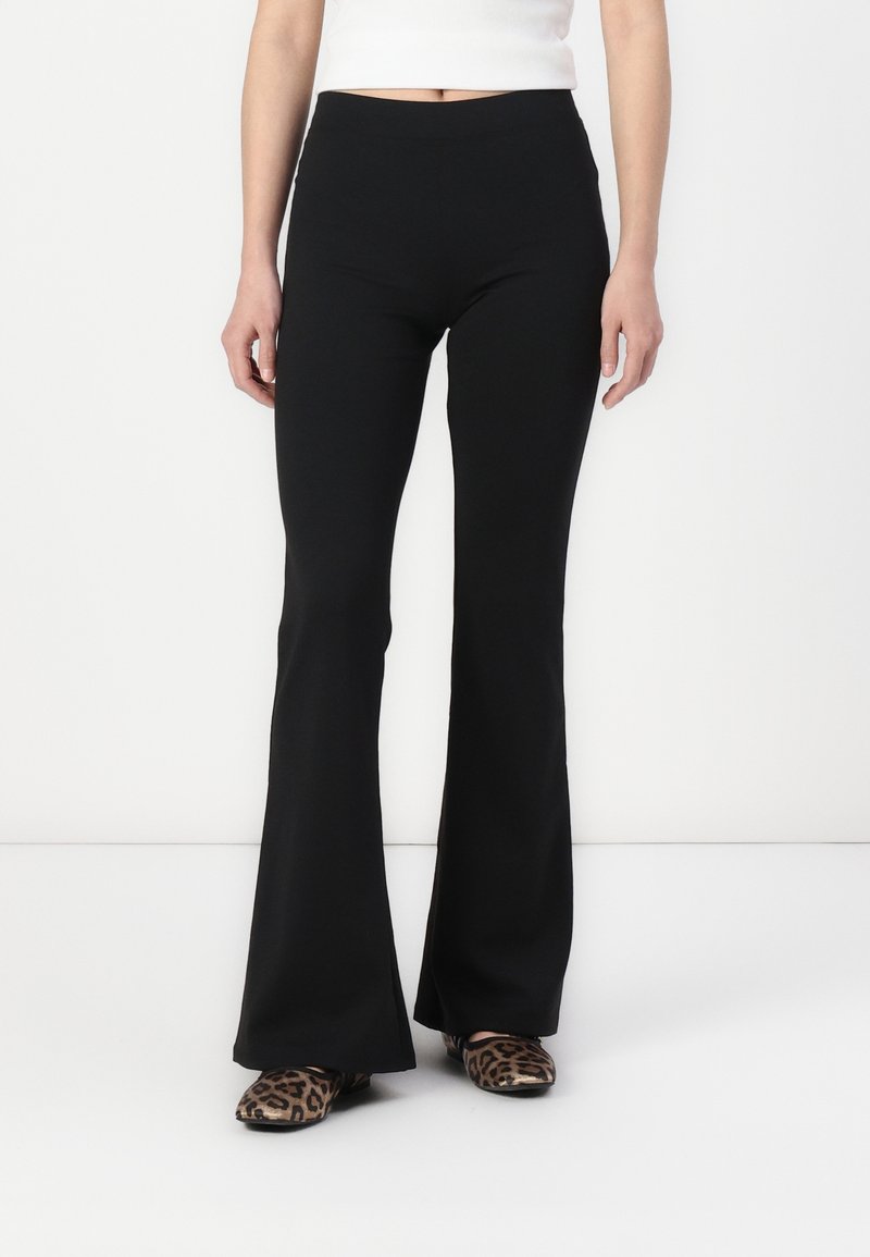 Black flared pants made of stretchy fabric. High waist, form-fitting through hips, and flared from knee to ankle. No visible patterns.
