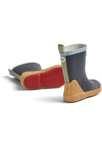 Bottes en caoutchouc bleu marine avec des finitions bleu clair, semelle beige texturée et fond rouge. Équipées d'une languette de traction verte à l'arrière.