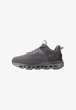Grauer atmungsaktiver Strick-Sneaker mit Schnürung, gepolsterter Sohle mit Luftlöchern, mit dem Markenlogo "Giesswein" an der Seite und Zuglaschen an Ferse und Zunge.