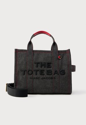 Borsa tote in feltro grigio con cuciture rosse, testo impresso "THE TOTE BAG MARC JACOBS", doppie maniglie superiori e tracolla nera removibile.