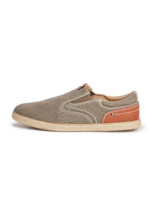 Zapatilla de lona beige sin cordones con costuras blancas, acento de cuero marrón en el talón, suela de cuerda de yute, punta redondeada y paneles laterales elásticos.