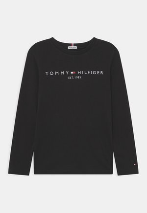 Camiseta negra de manga larga hecha de algodón, con un logo blanco "TOMMY HILFIGER EST. 1985" centrado en la parte delantera y un pequeño logo en la manga.
