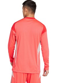 Sportshirt met lange mouwen in helder koraal met witte zijkanten. Gemaakt van een lichtgewicht, gestructureerde stof, met een klassieke pasvorm en ronde hals.