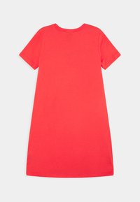 Czerwona sukienka z krótkim rękawem, wykonana z bawełny, z okrągłym dekoltem i luźnym krojem, o gładkiej fakturze bez widocznych wzorów.