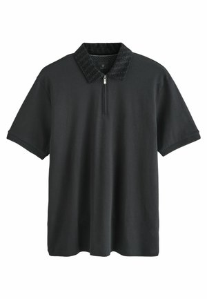 Zwarte polo met een gestructureerde zwarte kraag, korte mouwen, een ritssluiting bij de hals en een losse pasvorm. Gemaakt van zachte stof met een gladde textuur.
